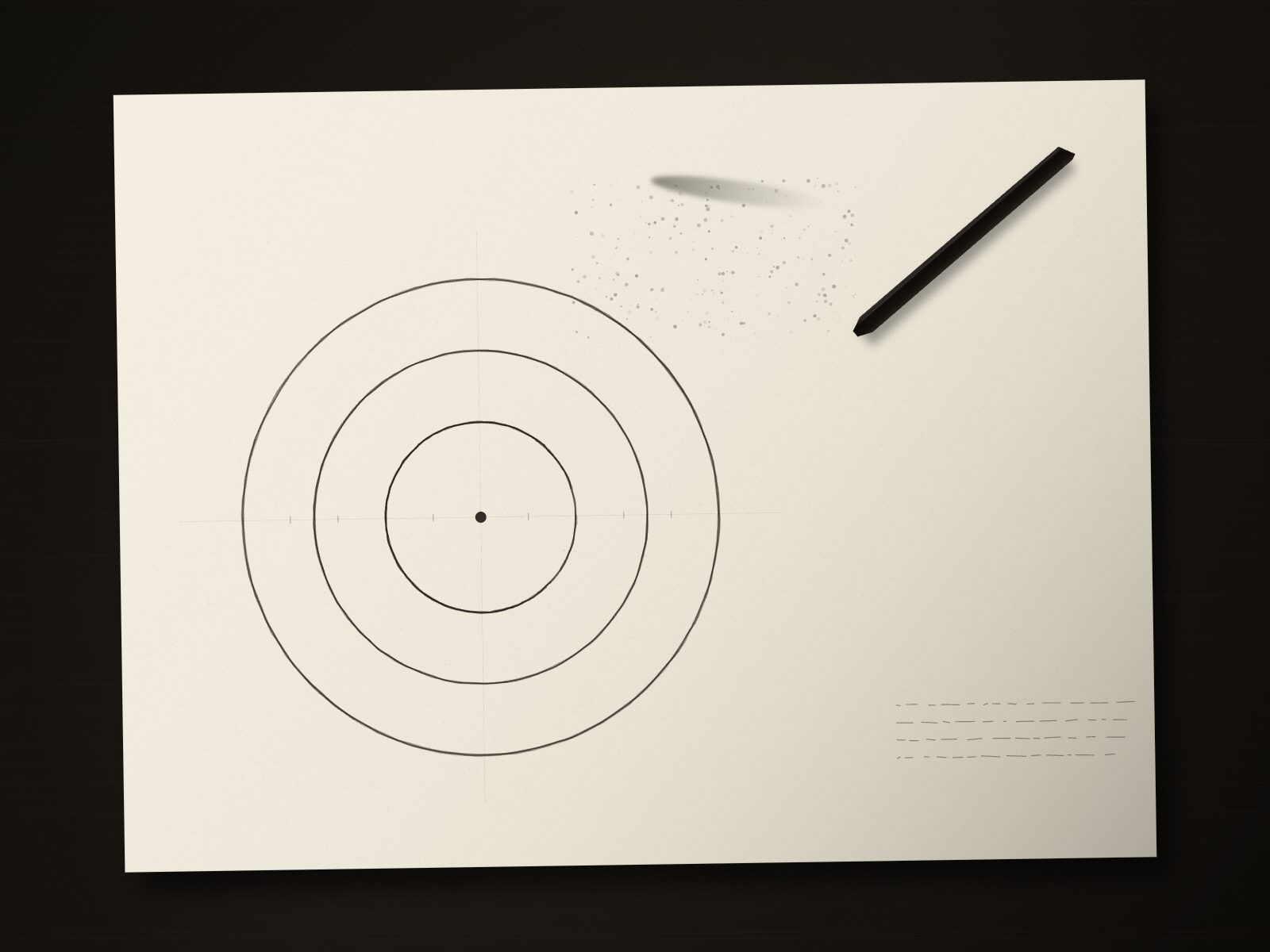 Top-down view of paper with a charcoal circle study and a stick of charcoal